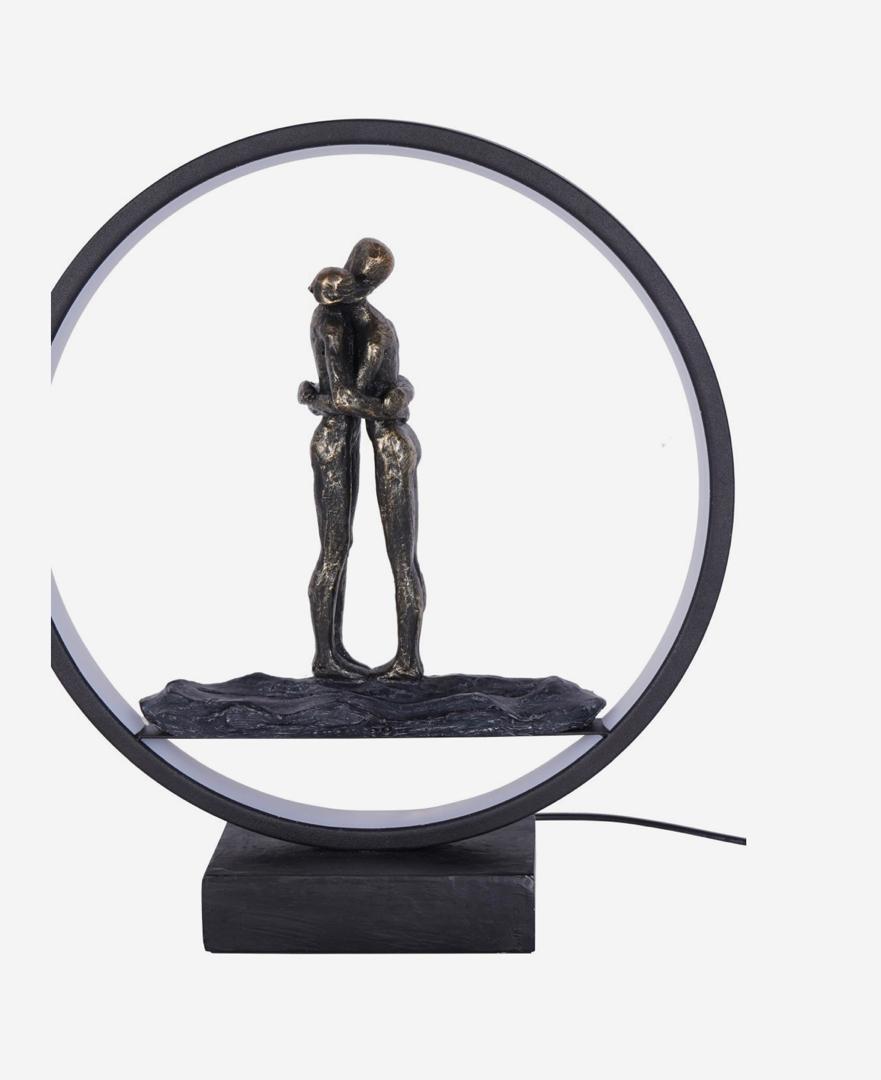 Hugging couple LED sculpture with bronze finish and circular light